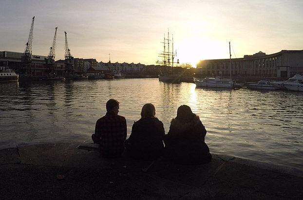 3 people sat overlooking the harbour in Bristol 