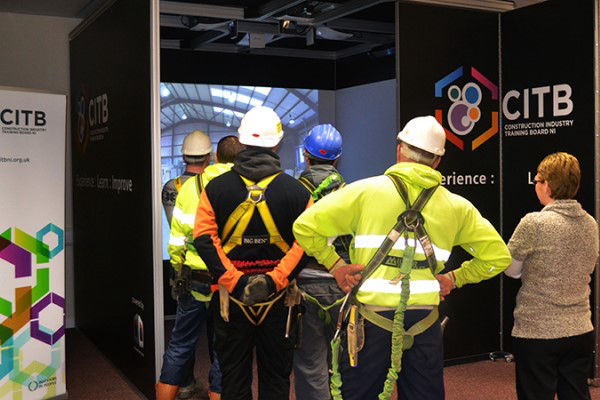 People in harnesses watching a training video on a Cube system
